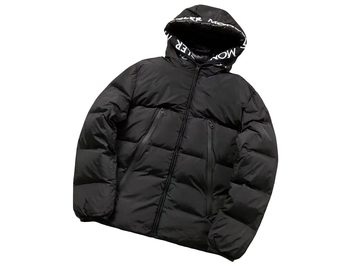 Moncler Black Oversized Down Jacket – All-Caps Logo Hood Brim Diagonal Baffles Matte Shell Chest Zip Pockets Comic-Strip Label Moncler Outerwear
